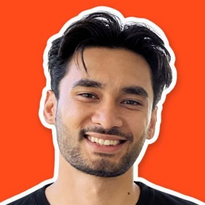 Faizi, smiling, against an orange background
